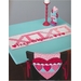 A white table runner with a pink XOXO patchwork top, reads 'hugs and kisses!'
