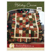 A red, pale green, and pale blue patchwork quilt made from charm squares with a scalloped border.