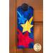 Door hanger kit for A-door-naments July with blue, yellow, & red shooting stars on deep blue fabric.