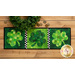 Table runner featuring three patchwork shamrocks on green print backgrounds.
