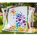 The beautiful Blooming Butterflies quilt draped over a chair outside.