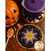 Two hot pads made with Halloween fabrics displayed on a table with a pot resting on one