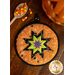 A Halloween spider web themed hot pad on a wood table with Halloween decor