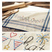 A vintage style dish towel with hand embroidered bunting, fireworks, and the words 