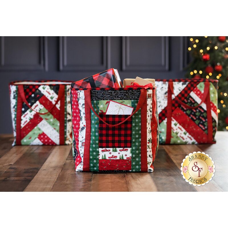 Three different Christmas shopper totes displayed on a table