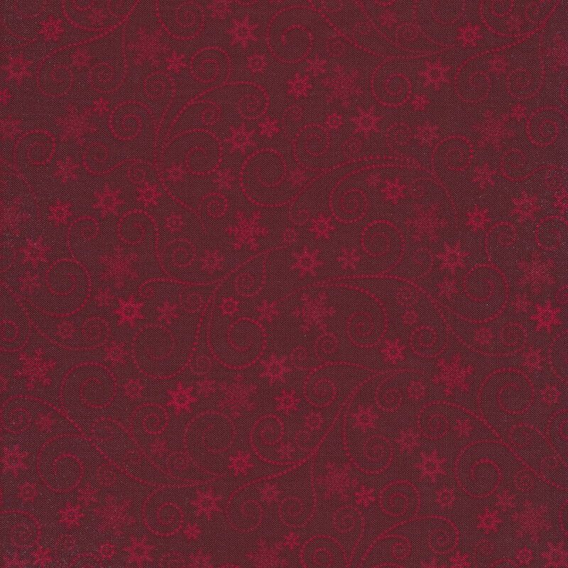 Red tonal fabric with dotted swirls, stars, and snowflakes