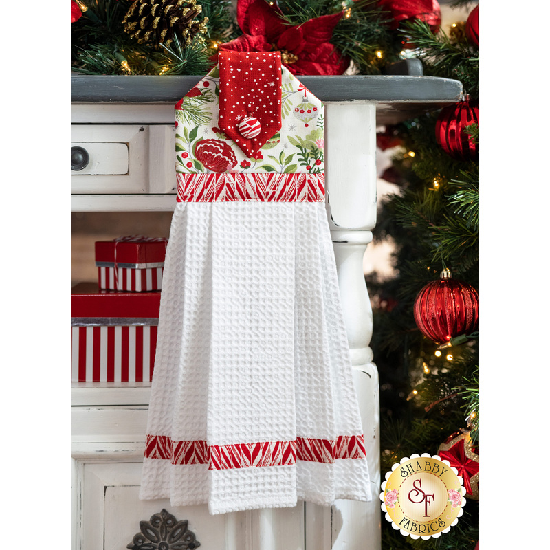 White and red towel with white waffle weave hanging from a cabinet