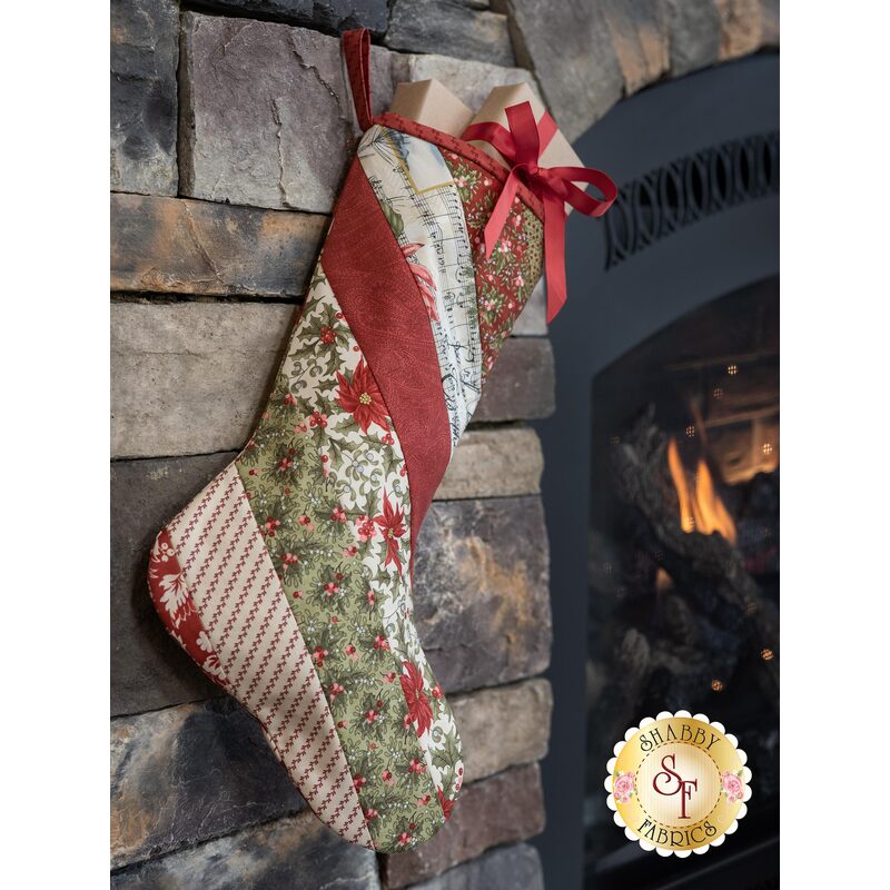 Beautiful red, white, and green Christmas stocking hung in front of a fireplace