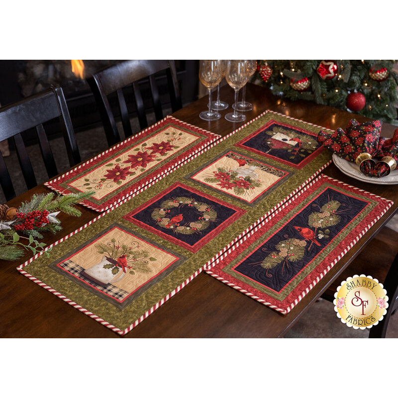 The Winterberry table runner and two accent runners displayed on a dark wood table