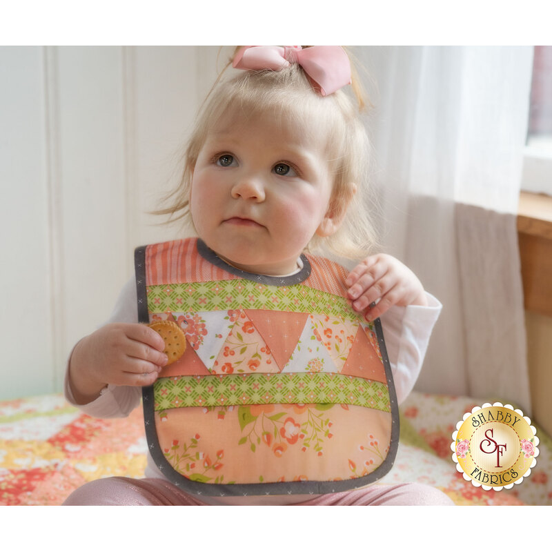 Adorable toddler wearing the triangle pieced Baby Bib - Apricot & Ash