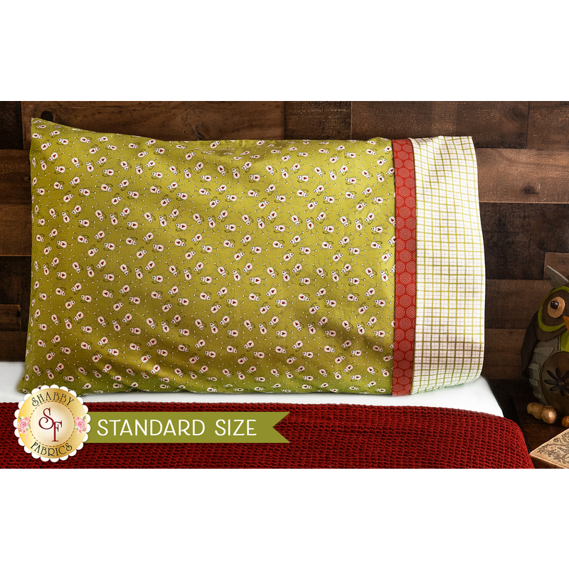 Bright green pillowcase with monkeys and a fun accent stripe resting on a bed