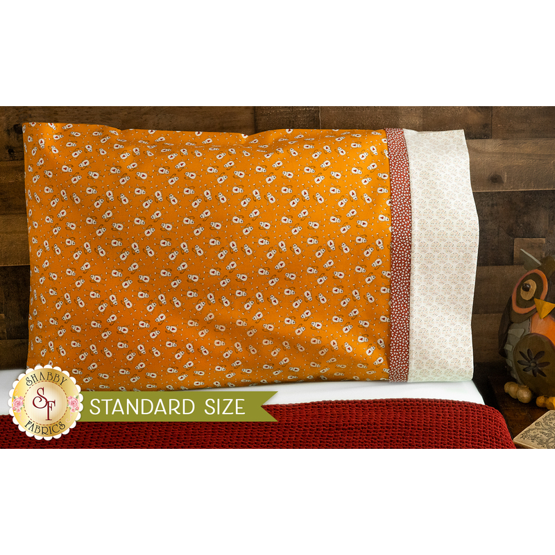 Bright orange pillowcase with monkeys and a fun accent stripe resting on a bed