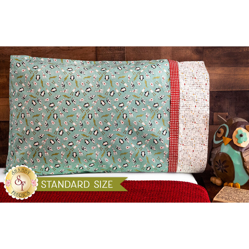 A teal, white, and red pillowcase with alligators, penguins and birds resting on a bed