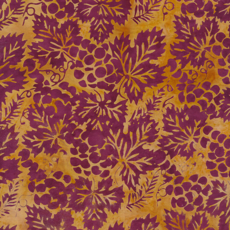 Dark purple grapes and autumn leaves on a yellow mottled background