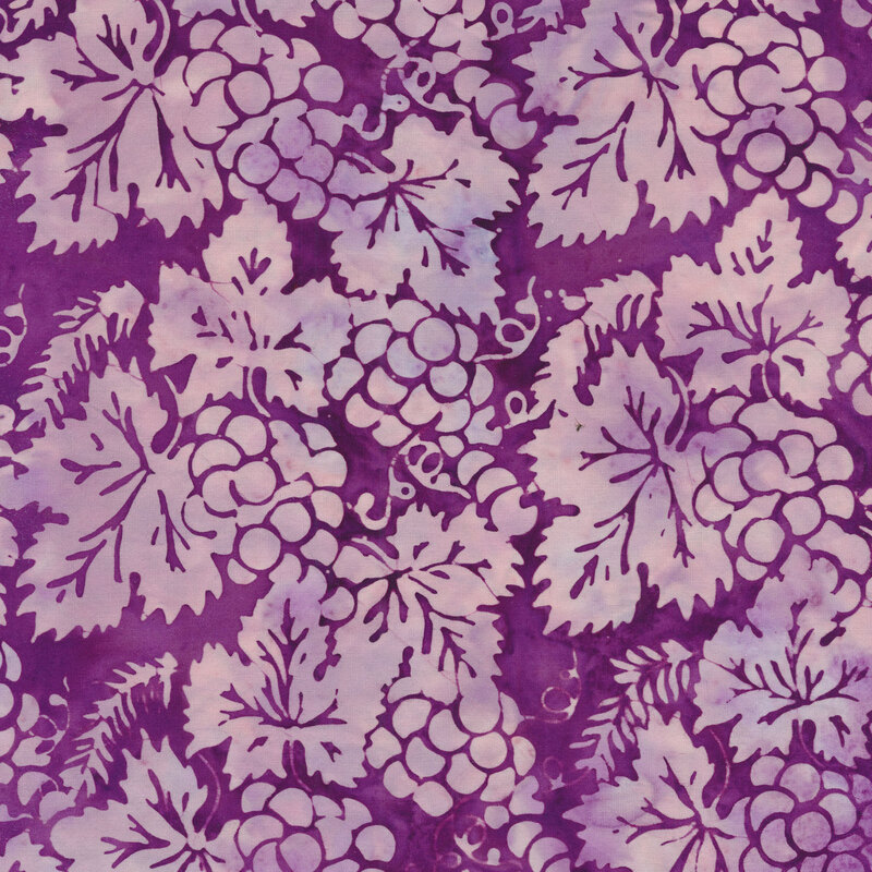 Mottled batik fabric with light purple autumn leaves and grapes on a dark purple background