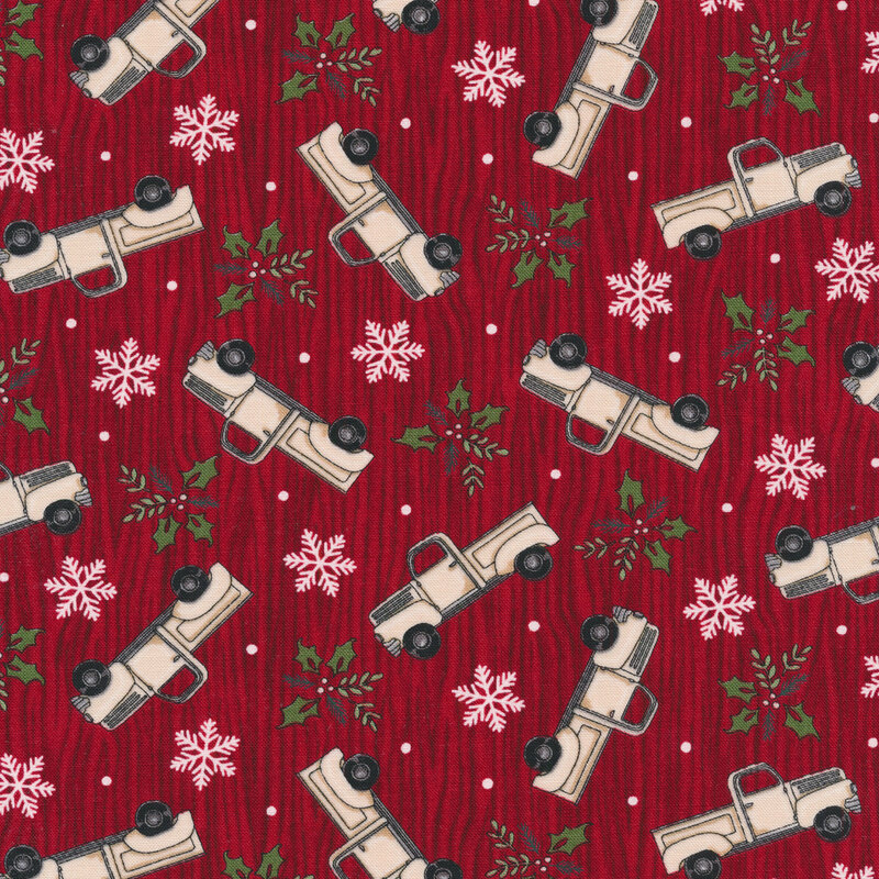 Tossed vintage trucks, snowflakes, and holly on a red wood grain background