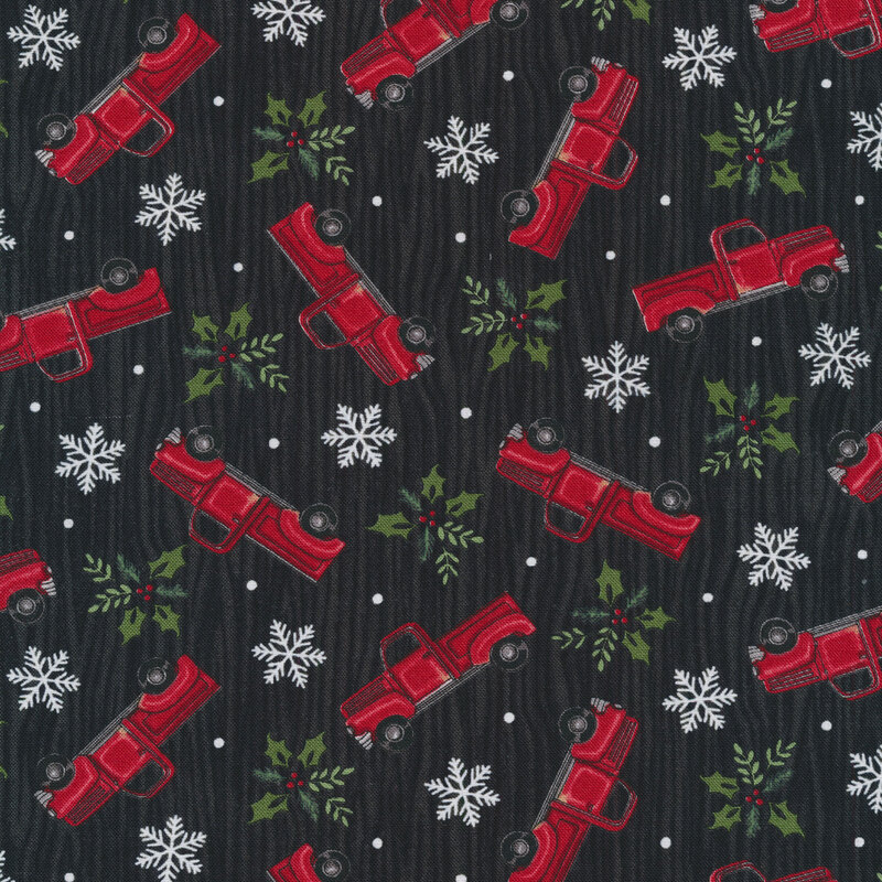 Tossed vintage trucks, snowflakes, and holly on a black wood grain background