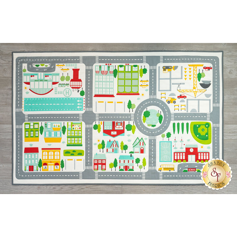 A top down view of the On The Go Canvas Playmat on a wood floor