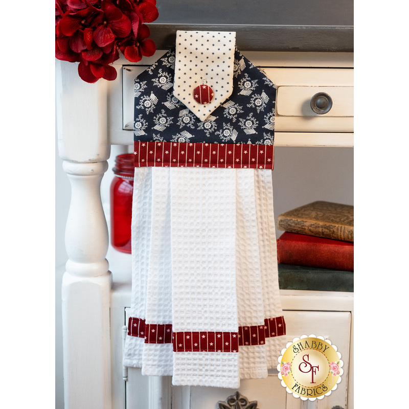 A beautiful patriotic themed hanging towel hung from a cabinet
