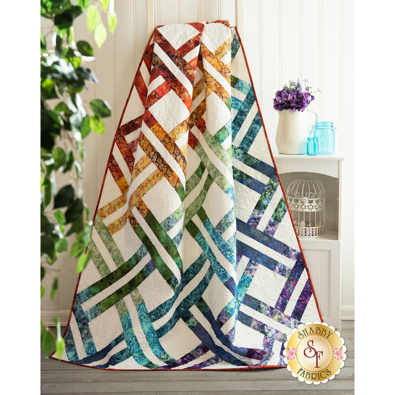 The beautiful Jelly Weave Quilt made with Floragraphix V fabrics draped over a ladder