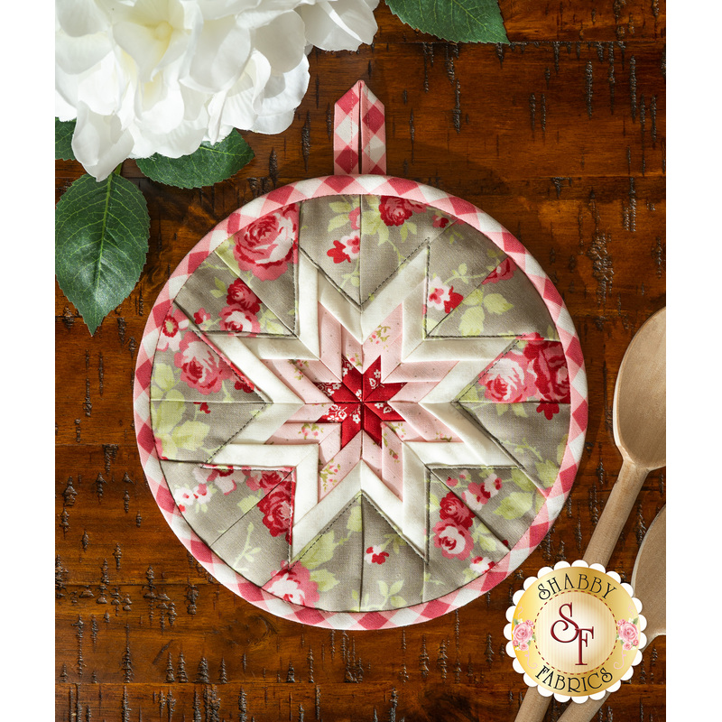 Grey and red floral hot pad on a wood table