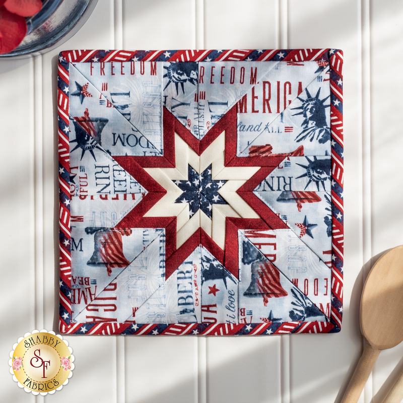 Red, white, and light blue folded star squared hot pad on a white paneled background