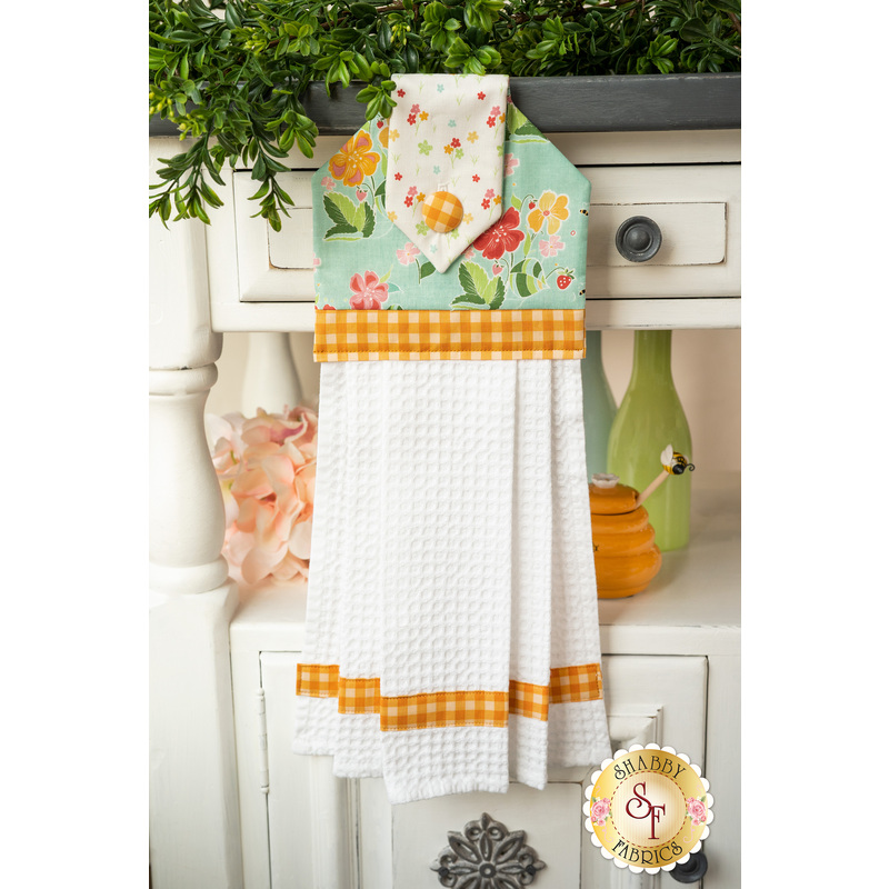 Aqua, orange, and white waffle weave hanging towel hung on a cabinet
