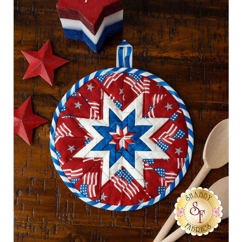 Patriotic red hot pad with tossed American Flags on a wood table