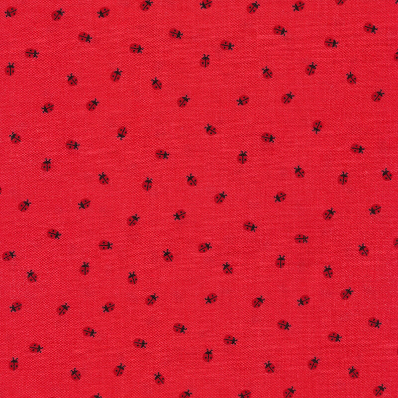 Tossed little lady bugs on a red fabric background