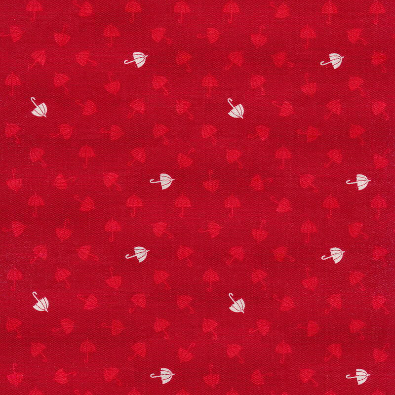 Tossed red and white umbrellas on a red fabric background