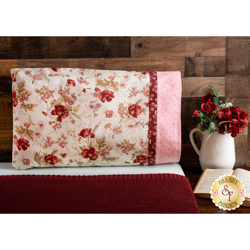Beautiful red, cream and pink floral pillowcase on a bed | Shabby Fabrics
