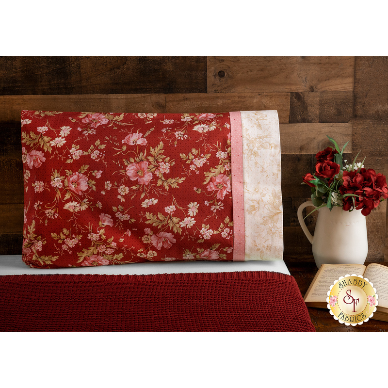 Beautiful red, cream and pink floral pillowcase on a bed | Shabby Fabrics