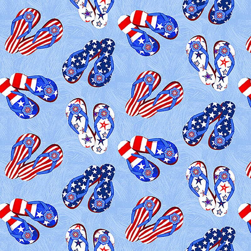 Tossed patriotic flip flops on a light blue textured background