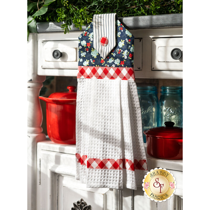A beautiful floral themed hanging towel hung from a cabinet