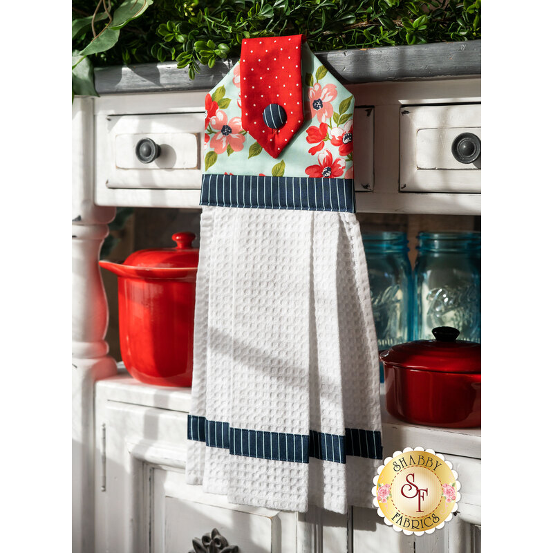 A beautiful floral themed hanging towel hung from a cabinet