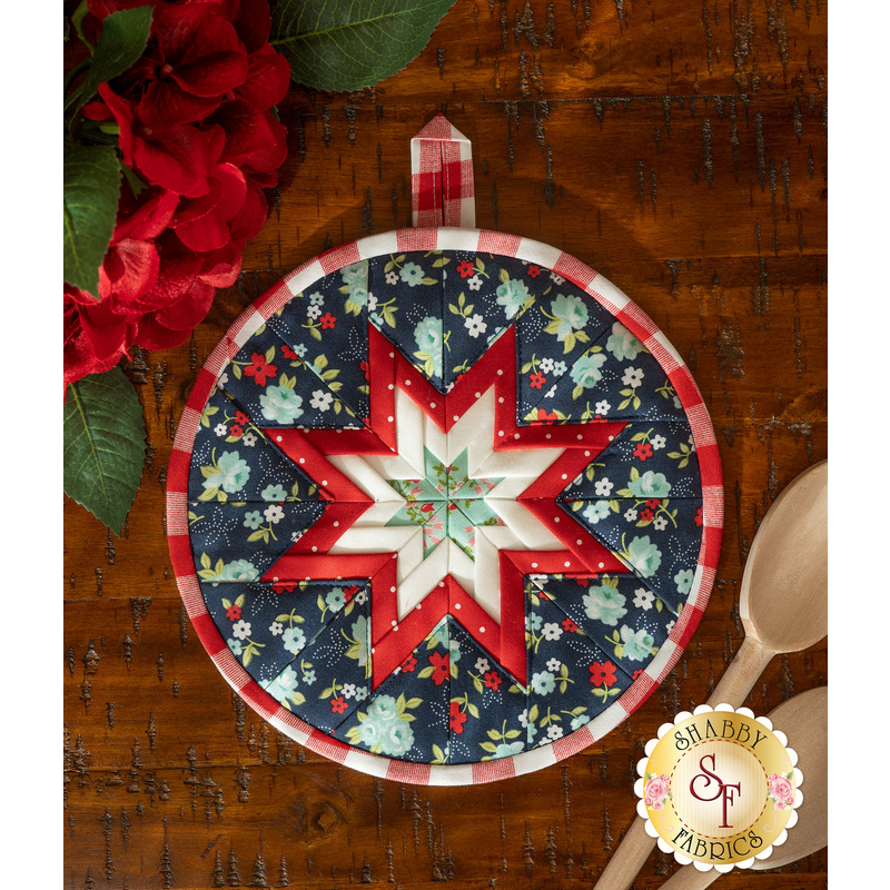 Navy blue floral circular hot pad on a wood table