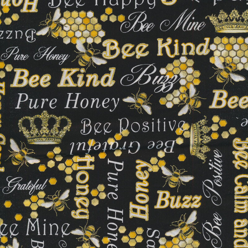 Metallic fabric with fun phrases, buzzing bumblebees, and gold crowns on a black background