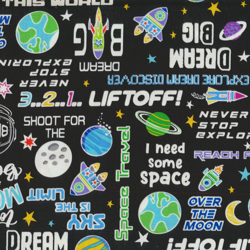 phrases, planets and spaceships all over a black fabric background 