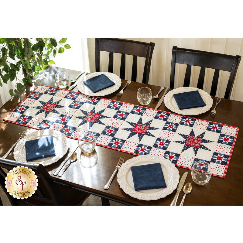 A beautiful patriotic table runner set in the center of a dark wood table