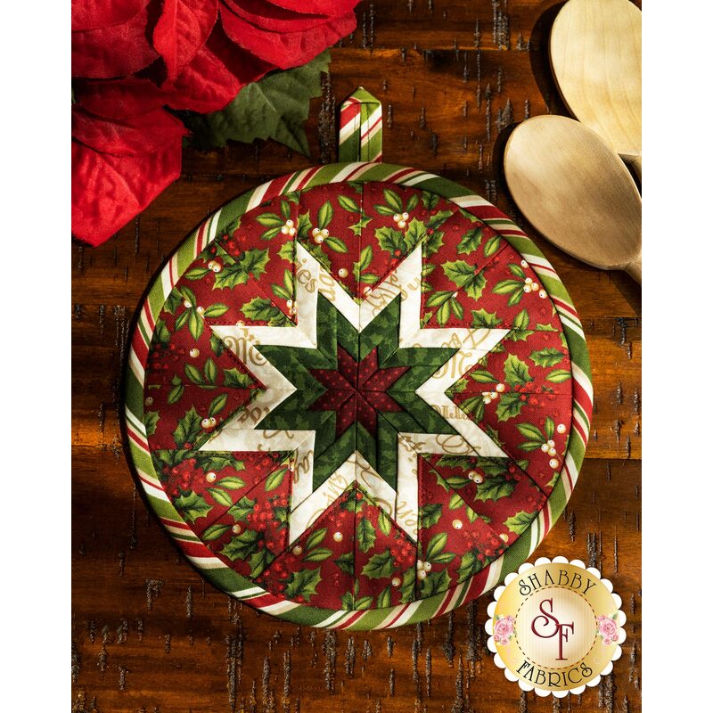 Navy blue floral circular hot pad on a wood table