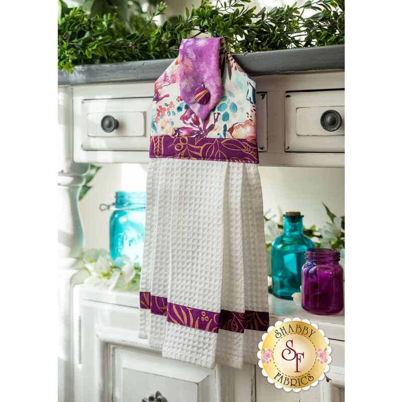 A black, red, and white Christmas hanging towel hung from a cabinet
