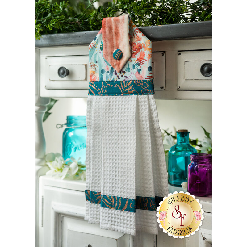 A black, red, and white Christmas hanging towel hung from a cabinet
