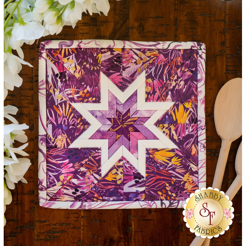 A purple squared hot pad on a wood table