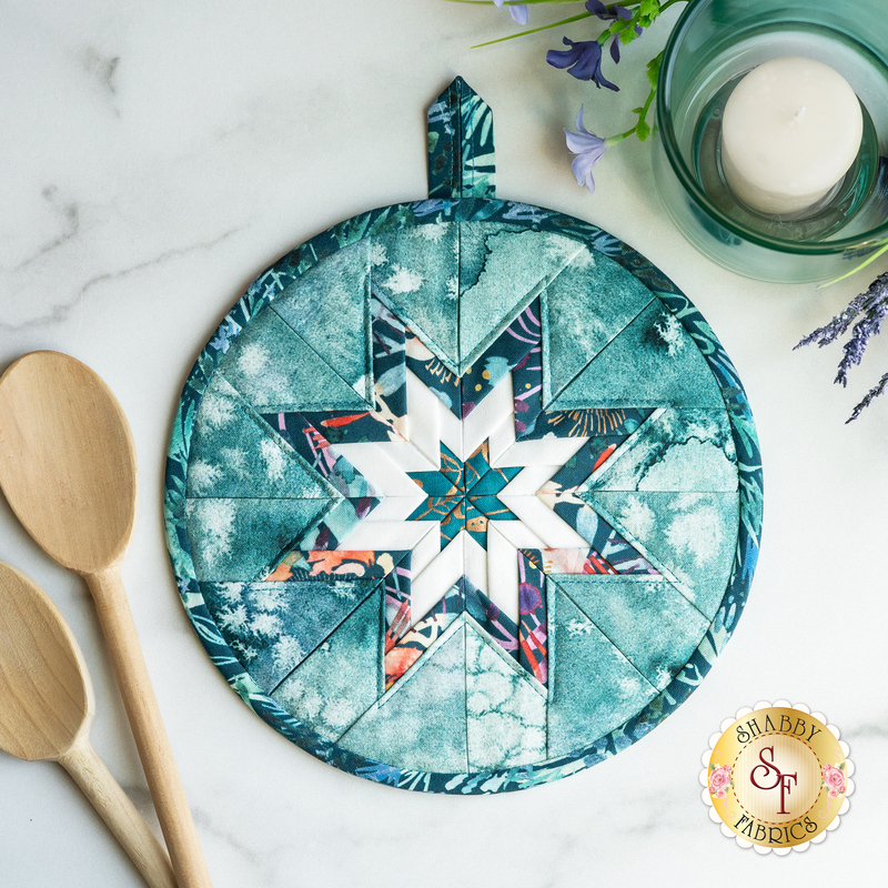 Navy blue floral circular hot pad on a wood table
