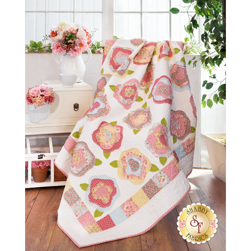 Pastel floral quilt with white background draped over furniture.