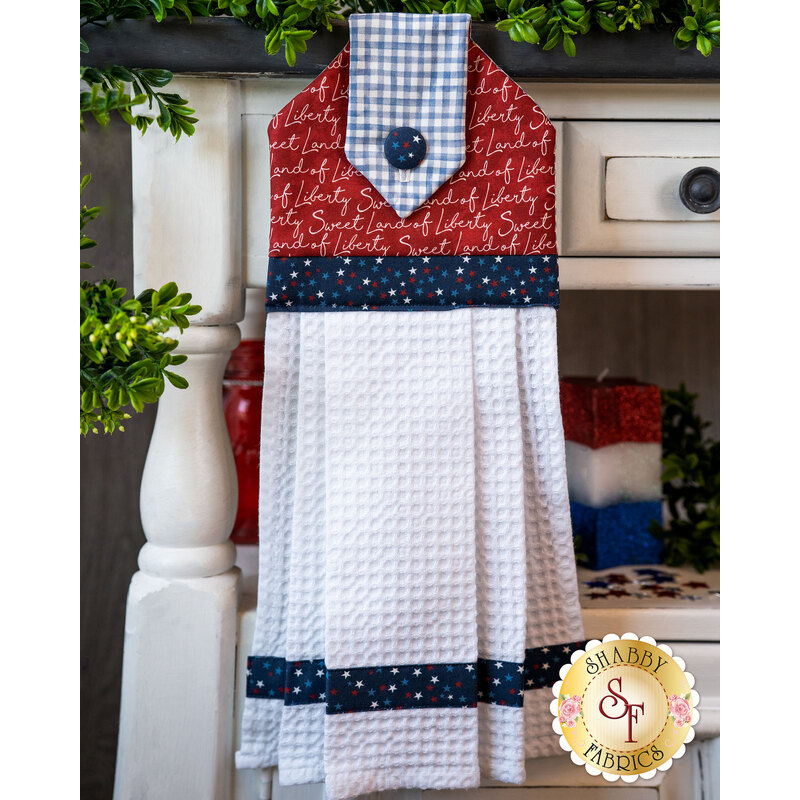 Hanging towel with patriotic phrases motif and waffle textured fabric.