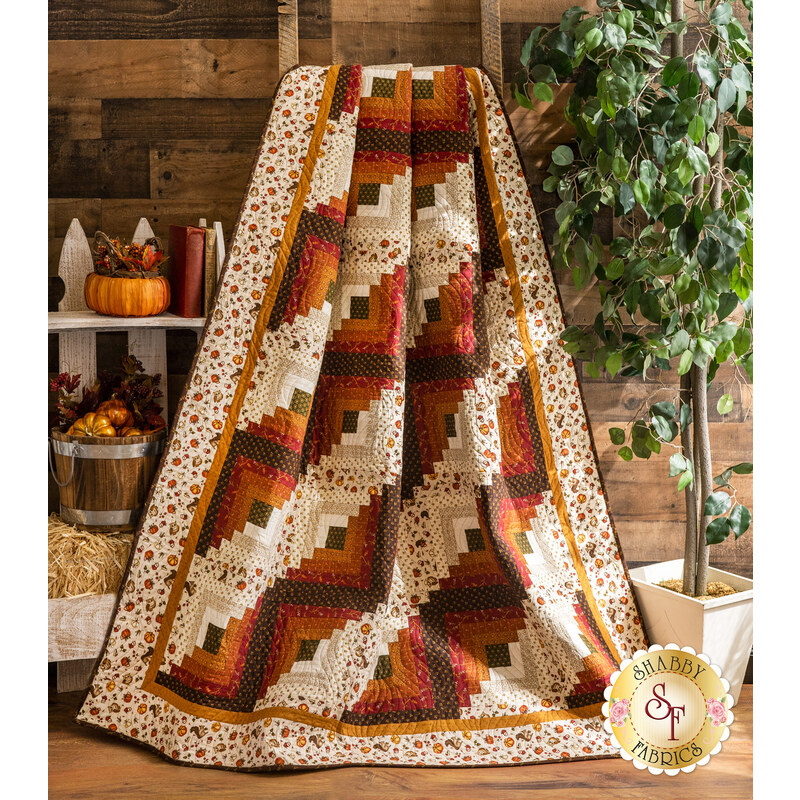 Autumn themed quilt draped over furniture.