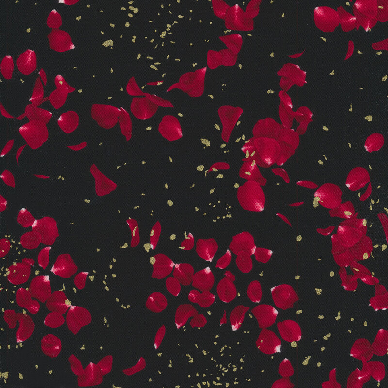 tossed red rose petals with gold metallic accents on a black fabric background