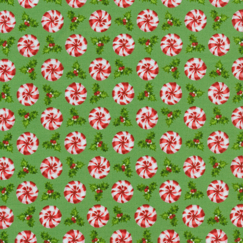 Green holiday fabric with red peppermint candy and Christmas holly
