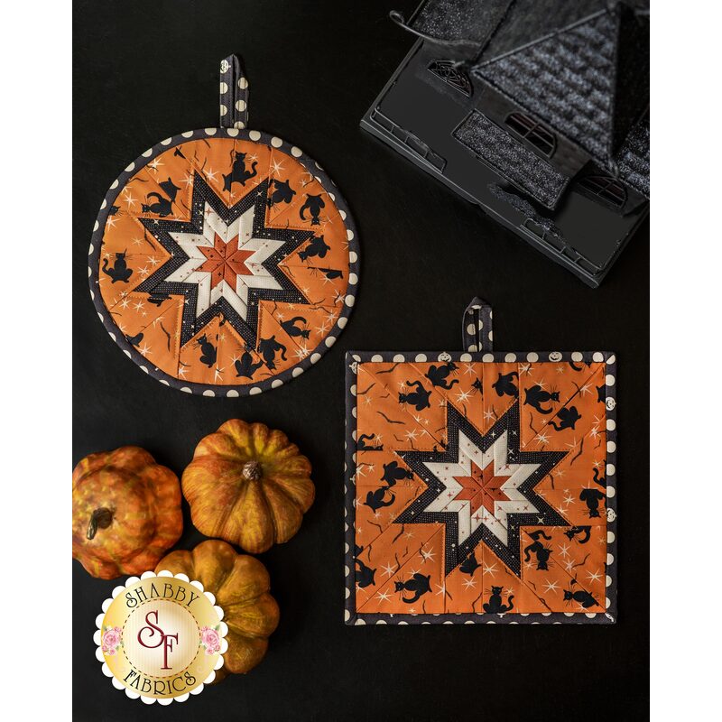 Halloween themed hot pads with central folded star design with orange fabric featuring black cats.